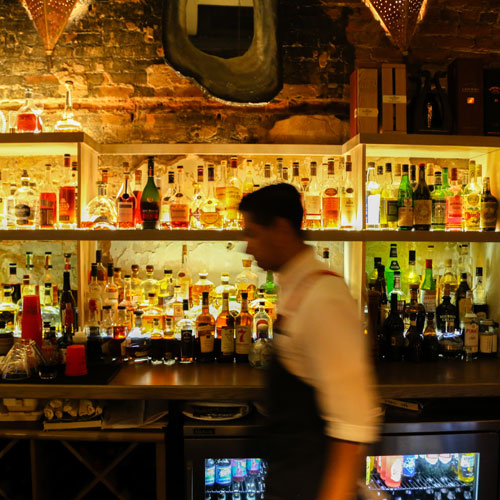 A server walks in front of the bar at the Oyster Bar