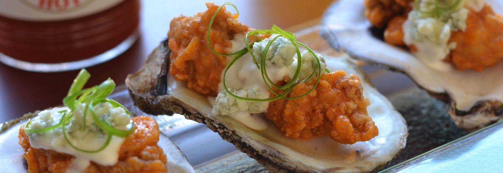 Red Fish Grill's famous BBQ oysters with a bottle of Crystal Hot Sauce ready to eat.